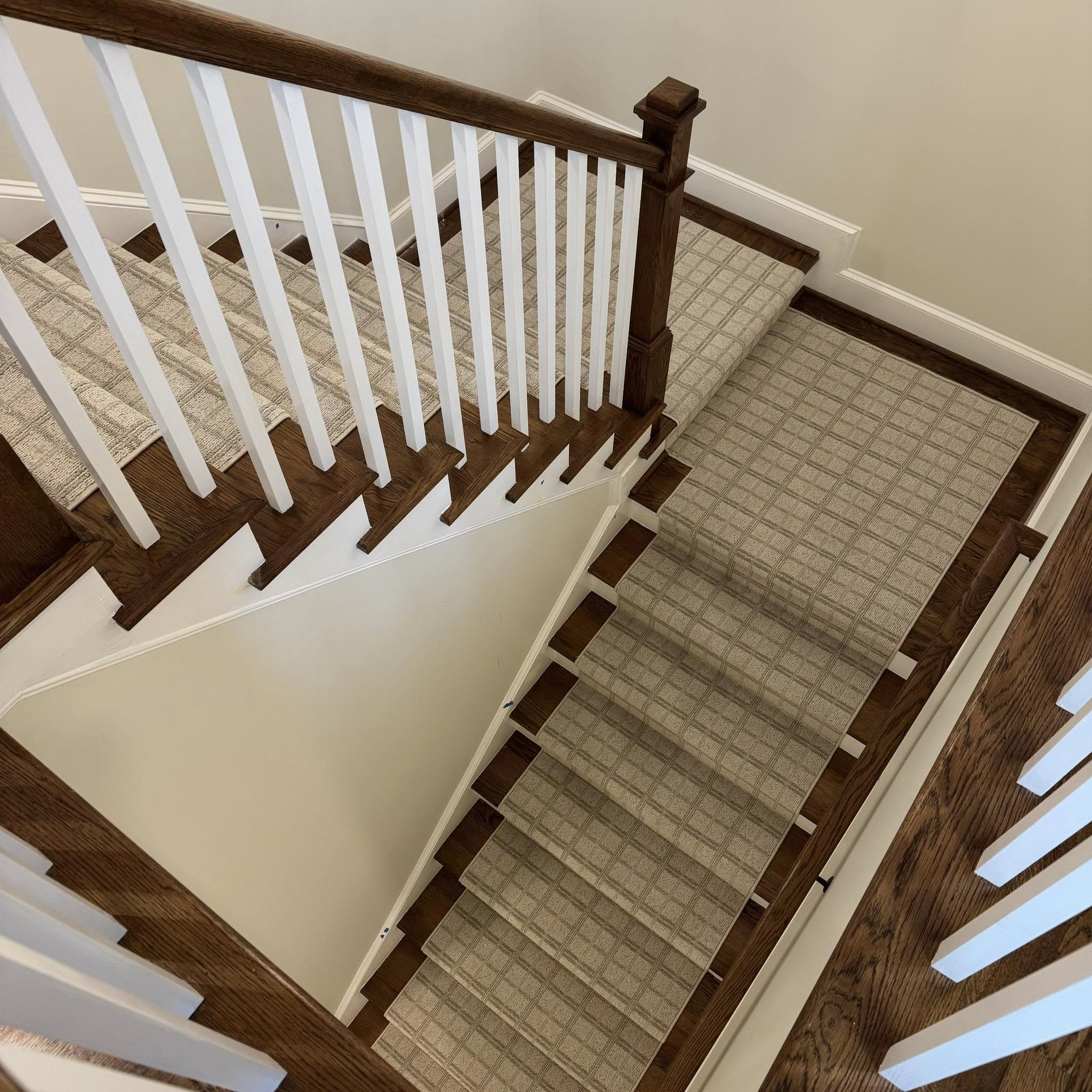 Expert craftsman installing custom stair runner with precision binding technique in Charlotte home
