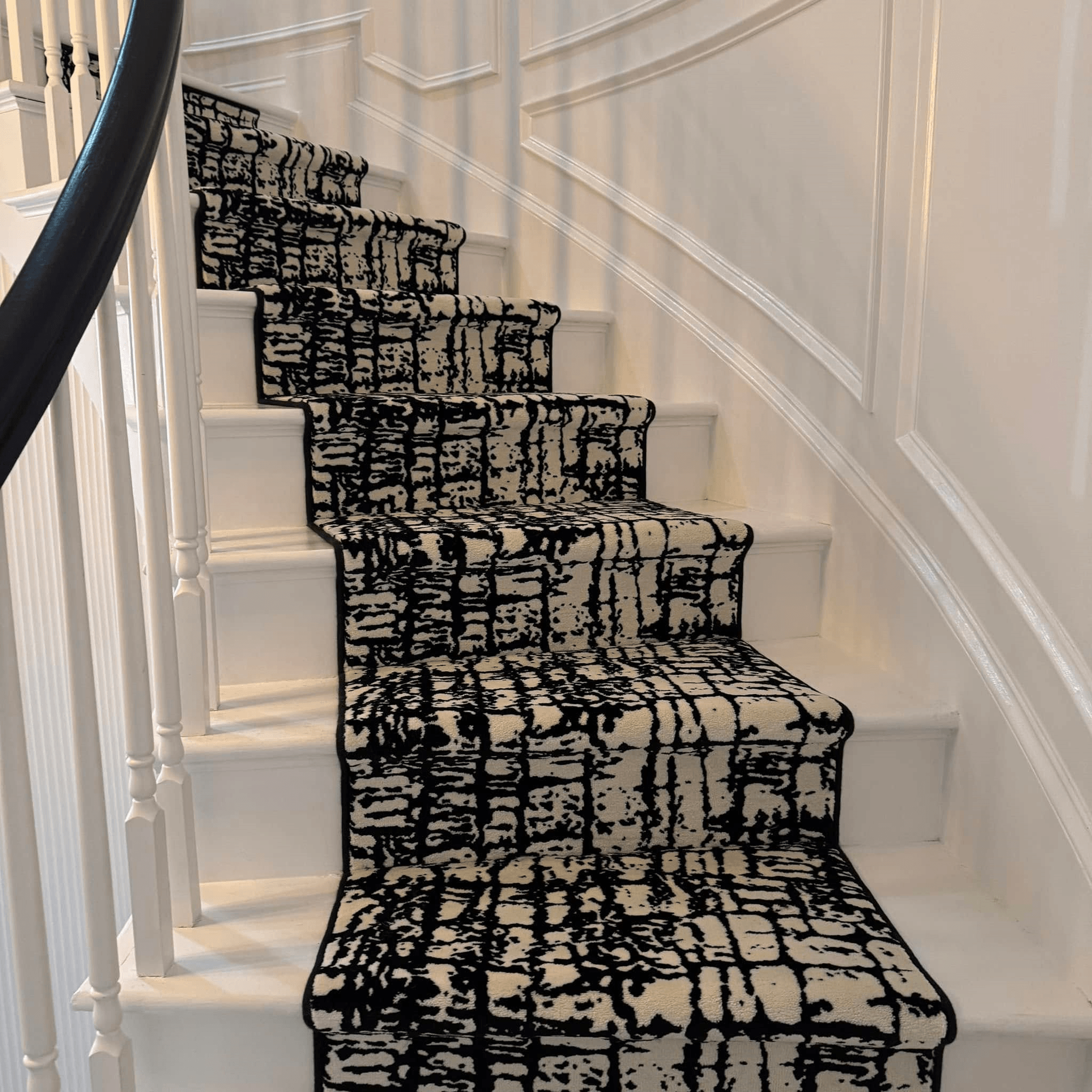 Luxury custom stair runner installation in Charlotte home with elegant pattern and professional binding
